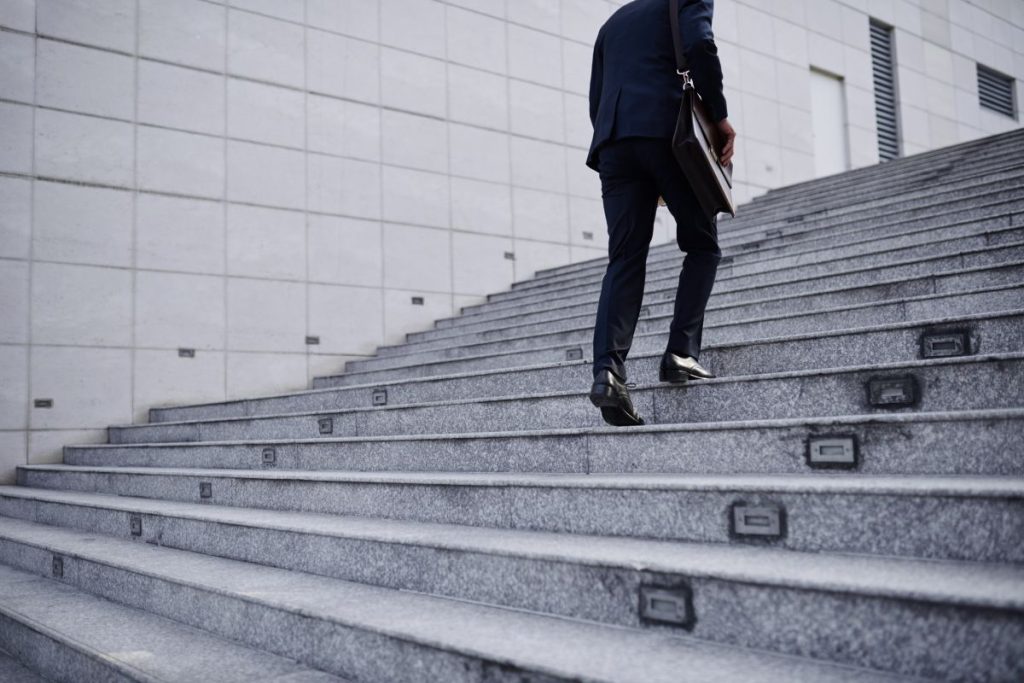 Cropped image of business person going up the stairs