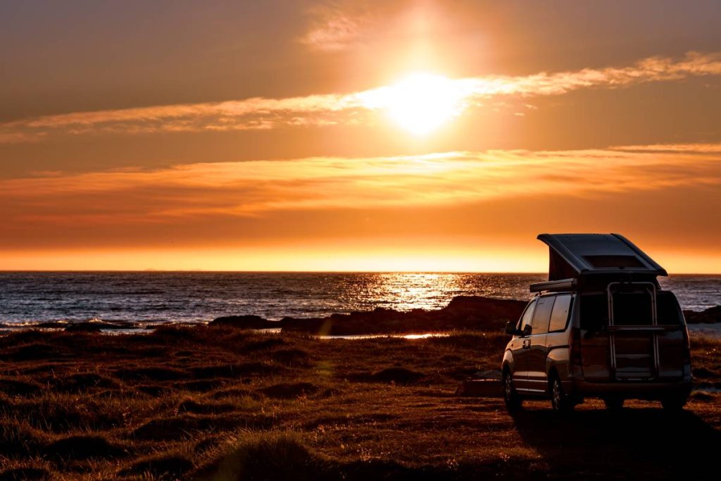 Camping car minivan on the beach at sunset. Beautiful Nature Norway natural landscape Lofoten beach.