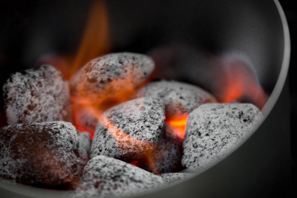 A closeup of coal briquettes being burnt with flames