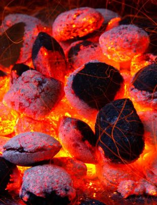 Glowing coal inside of a barbecue grill.