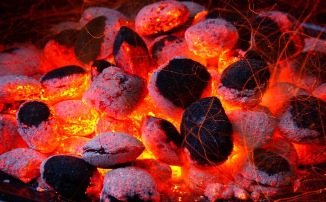 Glowing coal inside of a barbecue grill.