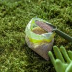 Fertilizer for grass growth in granules with gloves and scoop on the grass